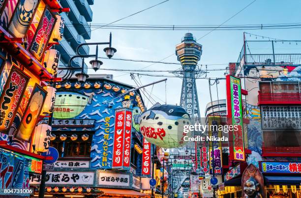 osaka tower and view of the neon advertisements shinsekai district - osaka stock pictures, royalty-free photos & images