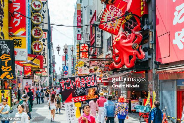 touristen, die in osaka dotonbori spazieren gehen - stadt osaka stock-fotos und bilder