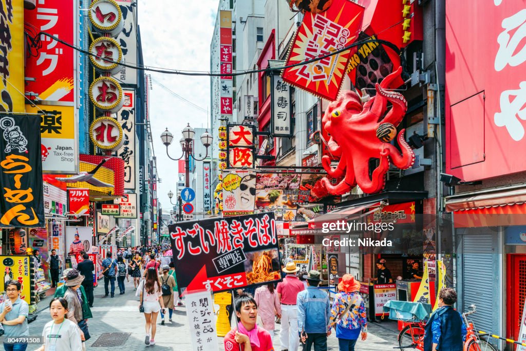 Tourists walking around crowded Osaka Dotonbori entertainment district