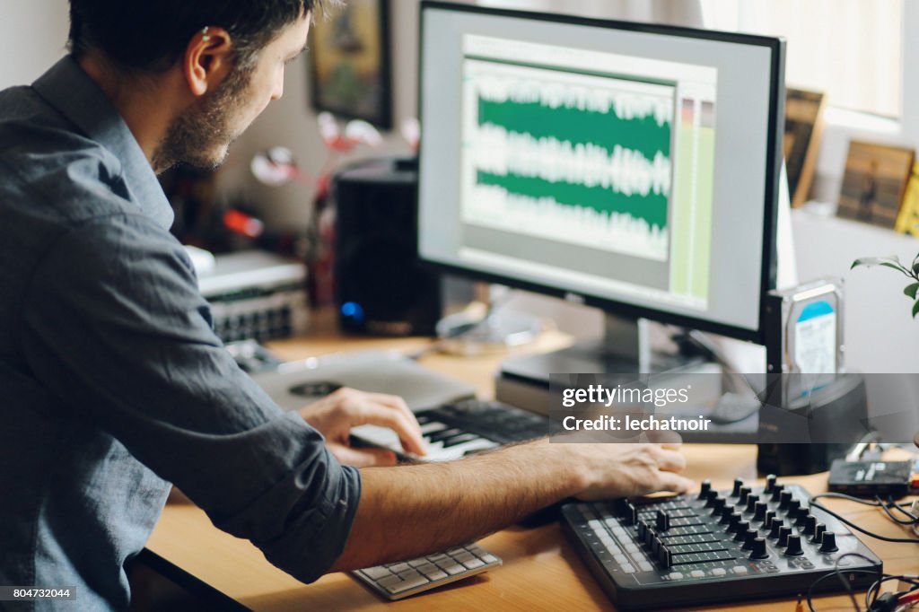 Young man creating music at home