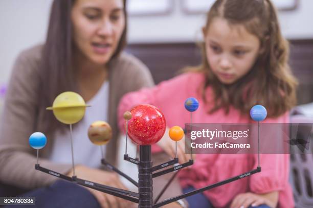 mother and daughter learning about astronomy together with model of planets - hawaiian women weaving stock pictures, royalty-free photos & images