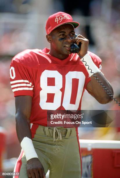 Jerry Rice of the San Francisco 49ers on the sidelines talking with coaches on the phone during an NFL football game circa 1990 at Candlestick Park...