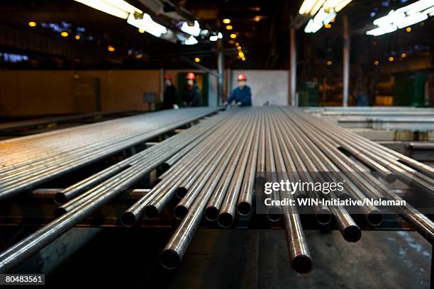 pipes in row with workers in steel factory - järn bildbanksfoton och bilder