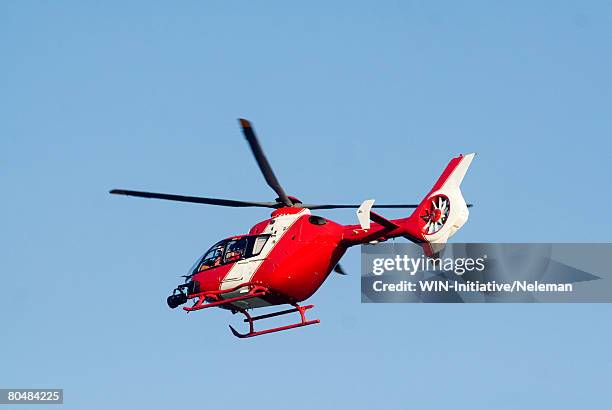 red rescue helicopter, low angle view - helicóptero - fotografias e filmes do acervo