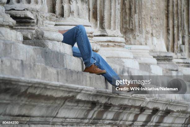 france, nimes, man relaxing by pillar - nimes stock pictures, royalty-free photos & images