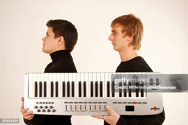 young men holding piano - synthesizer stock pictures, royalty-free photos & images