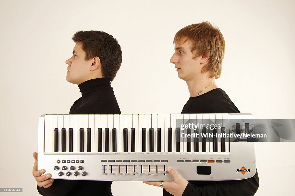 Young men holding piano