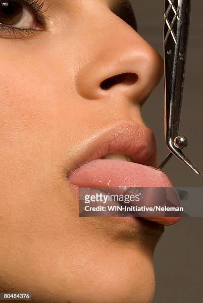 young woman with tweezers piercing on tongue  - pierced stock pictures, royalty-free photos & images