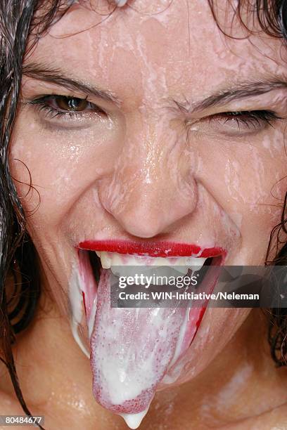 young woman sticking tongue, portrait - cream mouth stock-fotos und bilder