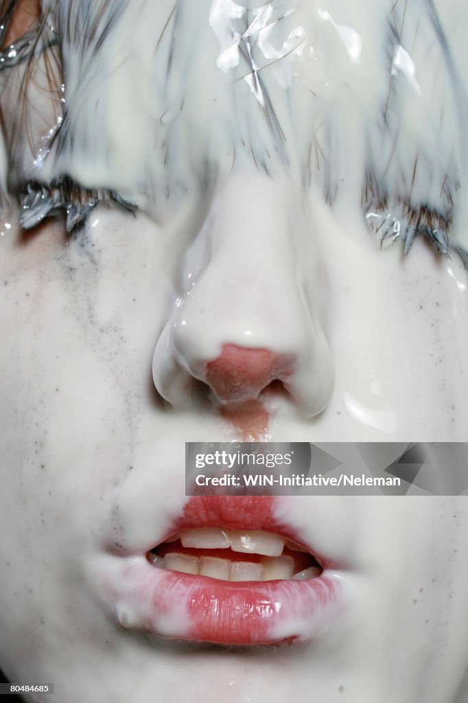 Woman's face covered with milk