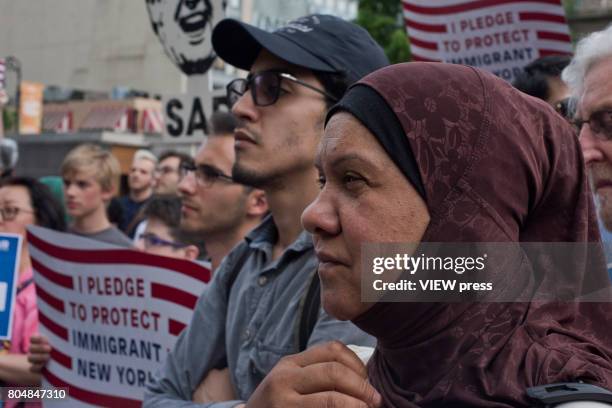 Immigrants join activists for an evening protest in Manhattan hours before a revised version of President Donald Trump's travel ban that was approved...