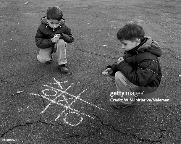 twins playing daggers-zeros outdoors (b&w) - tic tac toe stock pictures, royalty-free photos & images