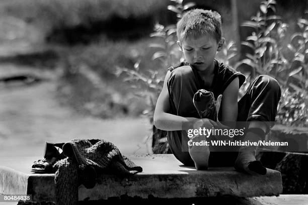 boy sitting on stone flag, wearing socks (b&w) - historical geopolitical location fotografías e imágenes de stock