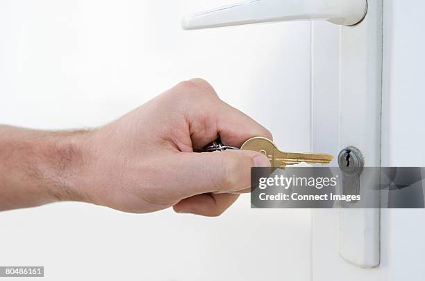 door and person with key - schloss-abschließen stock-fotos und bilder