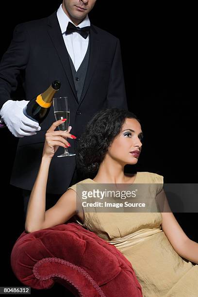 woman having champagne served by servant - servant stock pictures, royalty-free photos & images