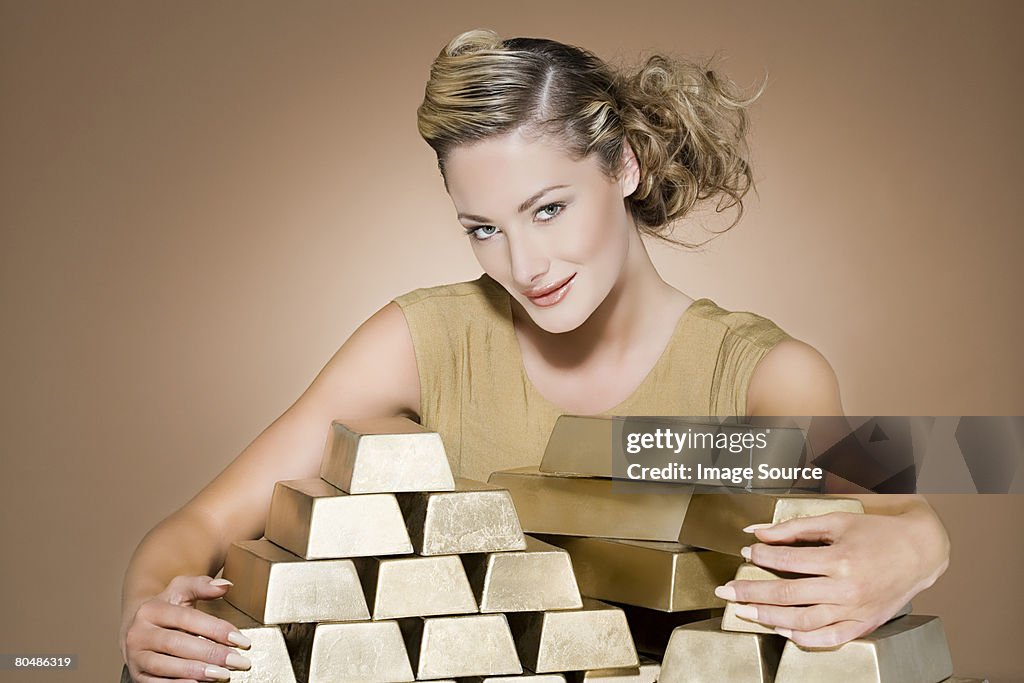 Woman grasping gold bars