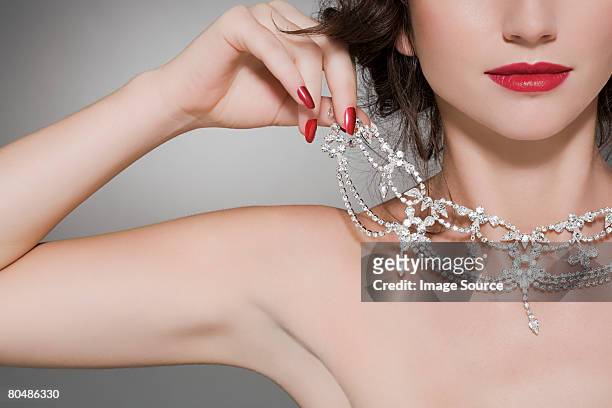 woman trying on a diamond necklace - diamond necklace stock pictures, royalty-free photos & images
