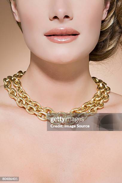 woman wearing a gold necklace - gold chain stockfoto's en -beelden