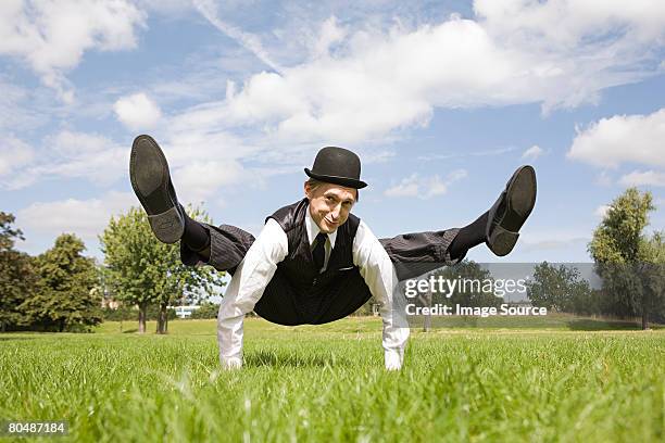 contortionist sitting in a field - contortionist stock pictures, royalty-free photos & images