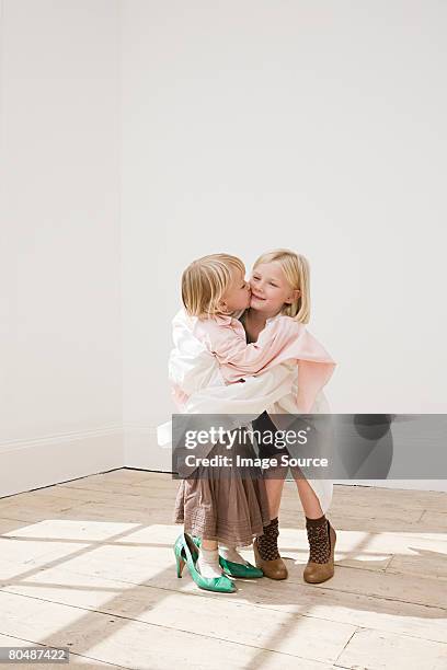 two young sisters kissing - kid in big shoes stock pictures, royalty-free photos & images