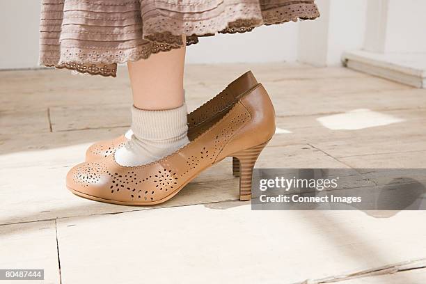 girl wearing large shoes - kid in big shoes stock pictures, royalty-free photos & images