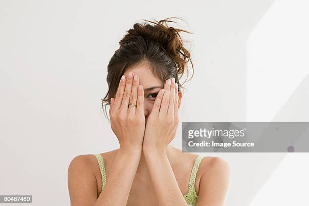 woman peering through hands - hand over bildbanksfoton och bilder