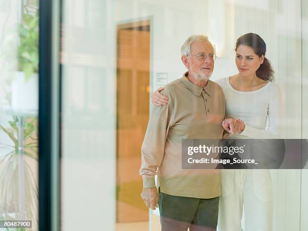 senior man being helped by woman - old man young woman stockfoto's en -beelden