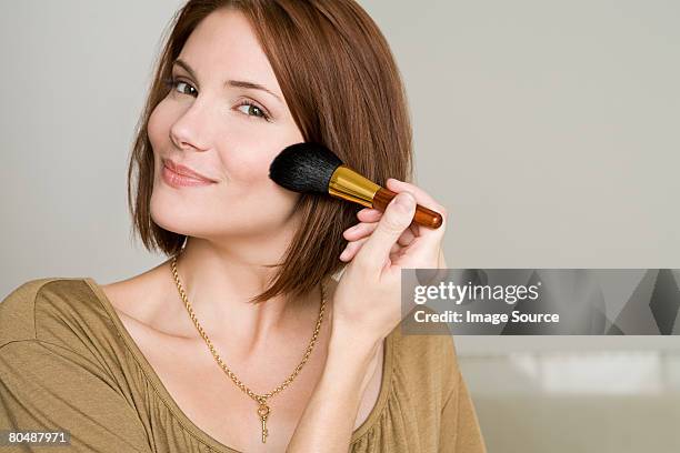 mujer aplicar maquillaje - rouge fotografías e imágenes de stock