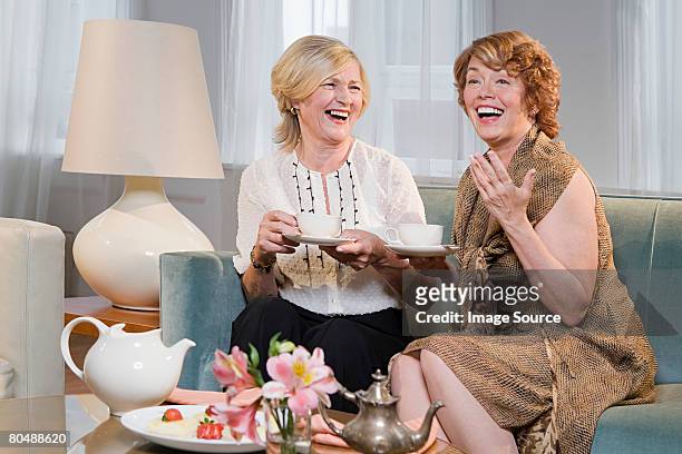 women laughing and having tea  - teapot stock pictures, royalty-free photos & images