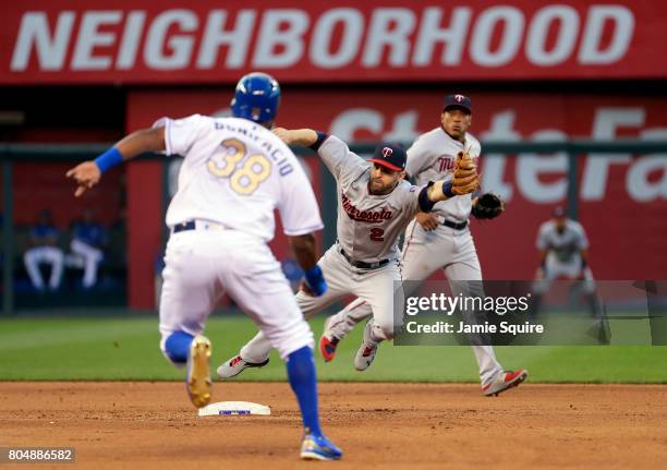 Brian Dozier of the Minnesota Twins misses a ball thrown by pitcher Ervin Santana resultng in an error as Jorge Bonifacio of the Kansas City Royals...