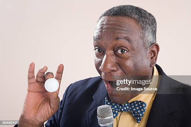 a bingo caller holding a bingo ball - bingo caller stock pictures, royalty-free photos & images