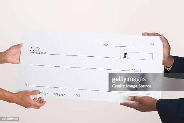 dos personas que agarra un cheque - charity cheque fotografías e imágenes de stock