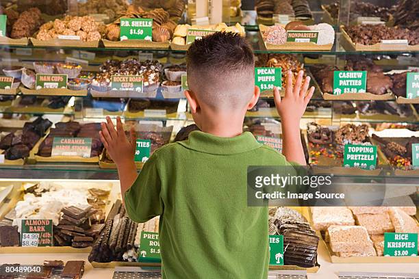 boy looking at cakes - snoepwinkel stockfoto's en -beelden
