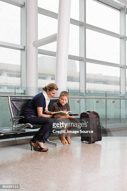 a mother reading a book with her son - child waiting stock pictures, royalty-free photos & images
