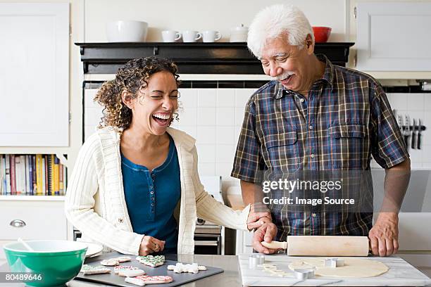 a father and daughter making cookies - father and grown up daughter stockfoto's en -beelden