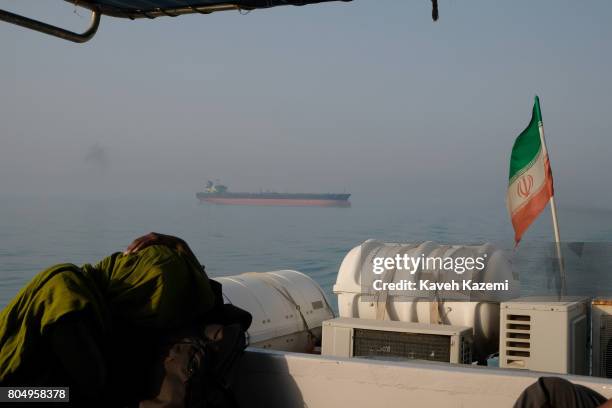 Foreign tourist rests on a passenger boat with the Iranian flag amass in the waters of the Strait of Hormuz on May 2, 2017 near Hormuz Island, Iran....