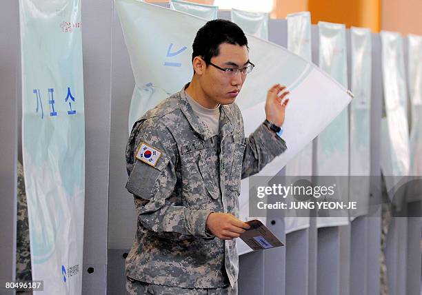 South Korean soldier walks out of a booth after casting his absentee ballot for next week's parliamentary elections at a polling station in Seoul on...