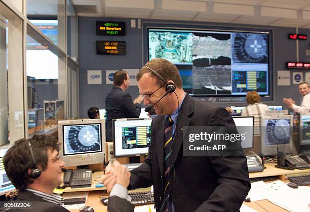 Engineers jubilate, on April 3 at the control room of the National Centre for Space Studies in Toulouse, in southwestern France, from where the...