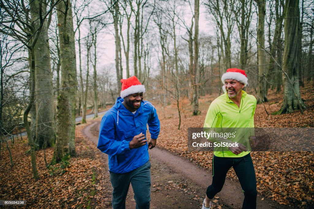 Two Joggers Up the Trails in the Forest at Christmas