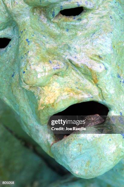 Lizard rests inside the mouth of a statue, by artist Kenneth Treister, which is on display as part of a sculpture depicting thousands of victims...