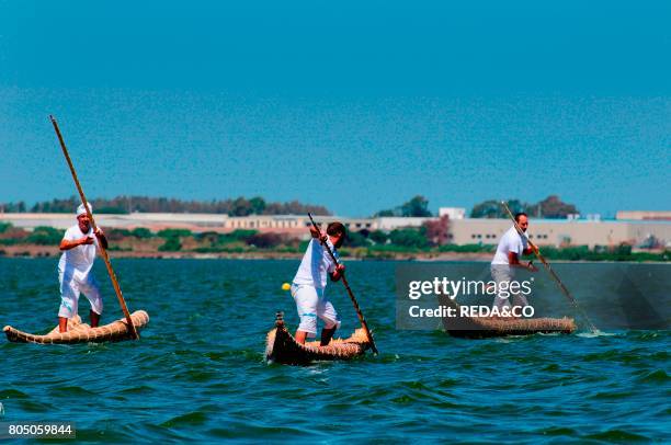 Fishermen sailing the Fassois. Typical canoe of Santa Giusta lake. Oristano. Sardinia. Italy.