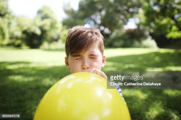 a 8 years old boy with a balloon in a park - 8 9 years stock-fotos und bilder