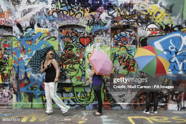 Three U2 fans add their names to the graffiti on the walls of Windmill Lane Studios in Dublin today.