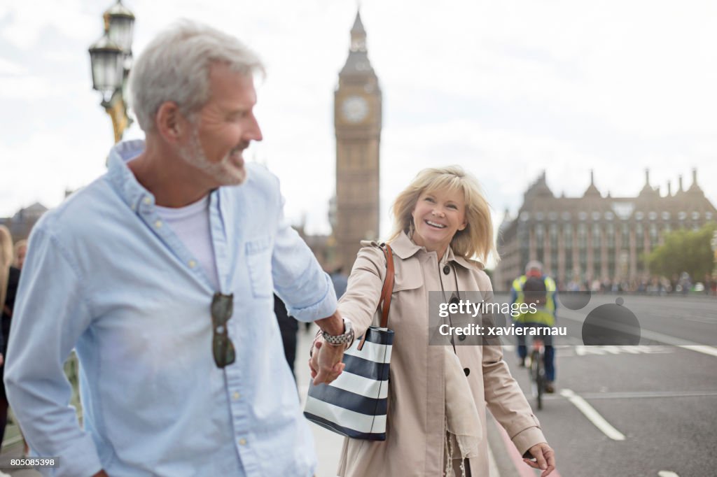 Sonriente pareja caminando por el puente de Westminster