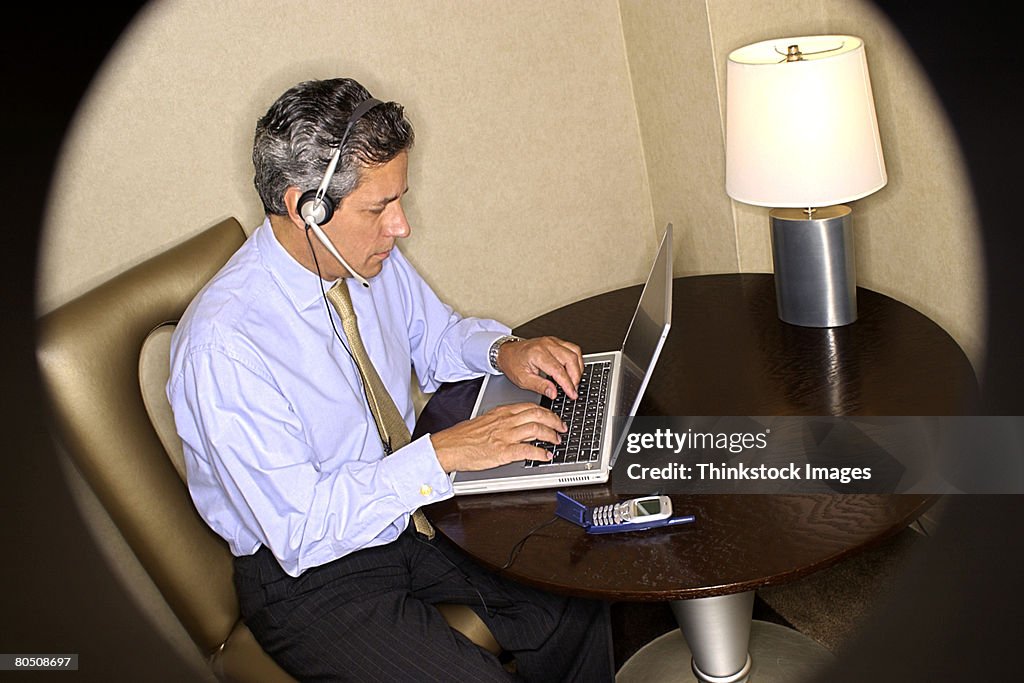 Businessman using laptop and headset