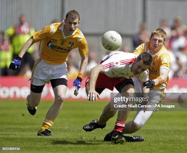 Tyrone's Philip Jordan is tackled by Antrim's Terry O'Neil during the Ulster Championship Football Final at St Tiernachs Park in Clones, County...