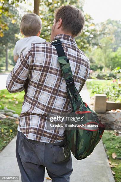 man carrying toddler - diaper bag stockfoto's en -beelden