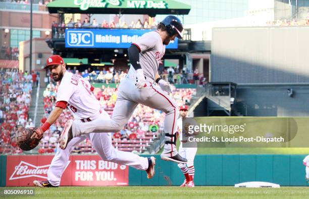 The Washington Nationals' Bryce Harper reaches first base safely as St. Louis Cardinals first baseman Matt Carpenter, left, is unable to catch the...