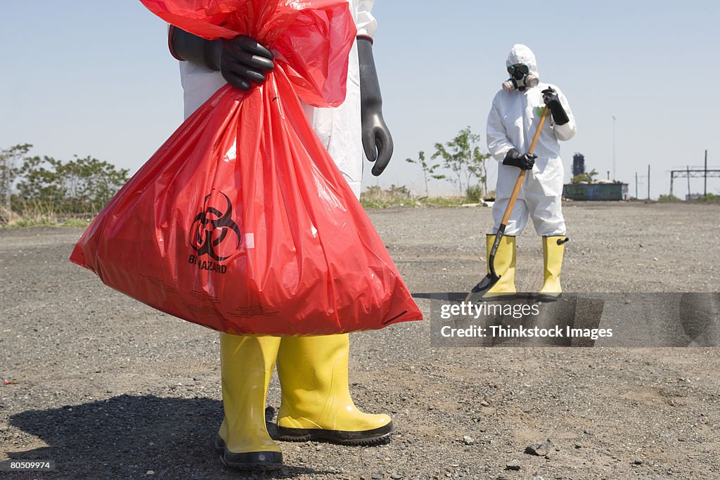 Workers wearing protective clothing removing hazardous waste
