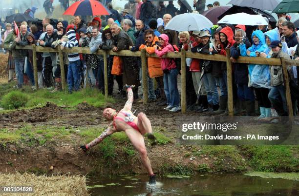 Competitor wearing a mankini performs falls into the 'Battle of the Somme' obstacle in the Nettle Warrior competition near Wolverhampton.